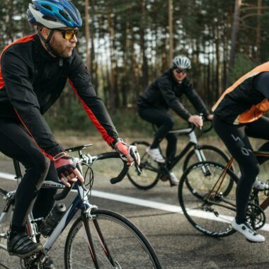 Group of cyclists on a scenic outdoor road, showcasing speed and athleticism.